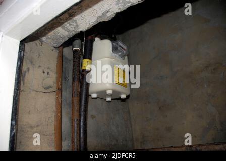 Contatore di gas tradizionale in una posizione scomoda in alto in un piccolo armadio esterno Foto Stock