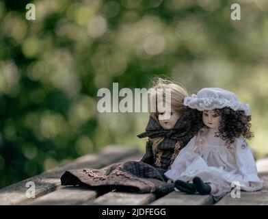 Bambole in porcellana d'epoca incredibilmente realistiche, giocattoli su sfondo verde Foto Stock