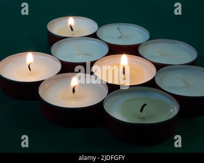 Un sacco di piccole candele accese. Atmosfera oscura e misteriosa. Sfondo  candela. Candele piatte rotonde Foto stock - Alamy