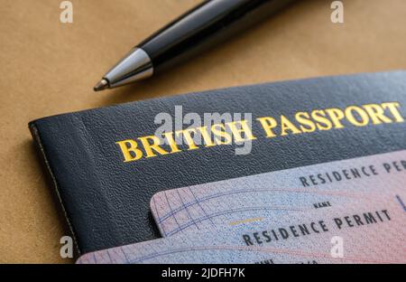 Carte di permesso di soggiorno biometriche (permesso indeterminato di rimanere, ILR) poste sopra il passaporto britannico. Concetto di naturalizzazione. Stafford, Regno Unito Foto Stock