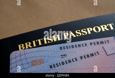 Carte di permesso di soggiorno biometriche (permesso indeterminato di rimanere, ILR) poste sopra il passaporto britannico. Concetto di naturalizzazione. Stafford, Regno Unito Foto Stock