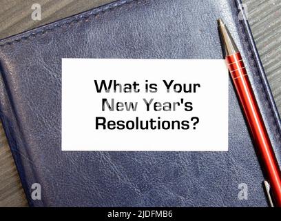 Vista dall'alto di Office Desk e blocco note con testo - Qual è la risoluzione del nuovo anno. Foto Stock