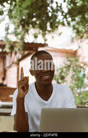 Multiculturale verticale, mix uomo raced in occhiali con laptop, indicizzazione, puntamento, nuove idee. Lavorare, studiare online Foto Stock