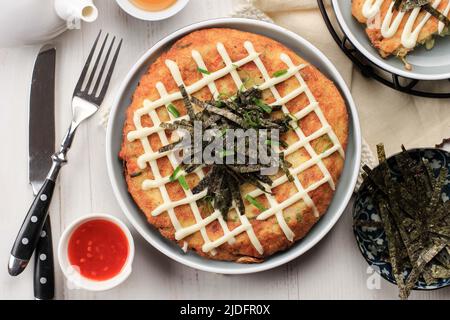 Japanase Food: Okonomiyaki, pizza Pancake giapponese in stile salato. Preparare da Mix verdure e carne, con maionese e Topping Nori. Vista dall'alto Foto Stock