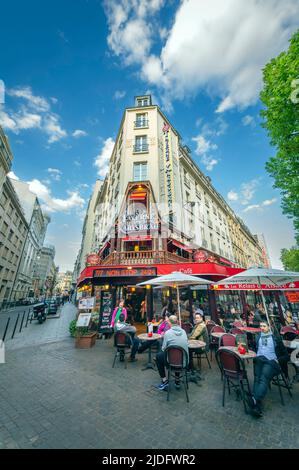 La gente cenerà fuori su un patio aperto di un ristorante tipico Parigino Foto Stock