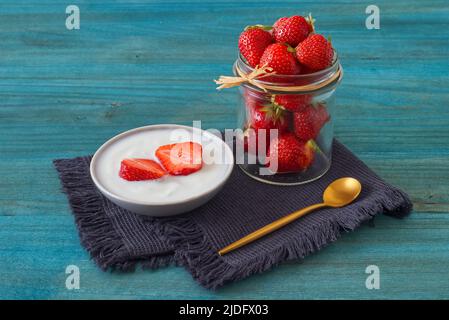 Ciotola di fragole fresche con creme fraiche, gustoso dessert di frutta, senza persone, closeup basso angolo. Foto Stock