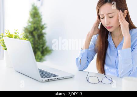 Stressato e mal di testa donna d'affari che lavora in ufficio Foto Stock