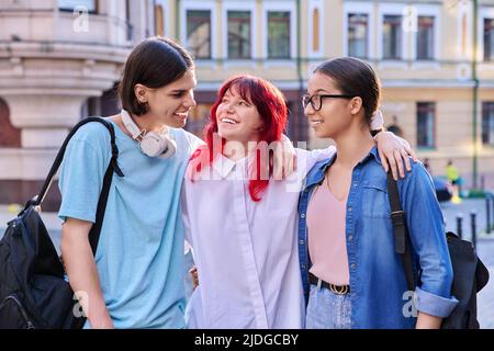 Felici sorridenti amici adolescenti che abbracciano all'aperto, sulla strada della città Foto Stock