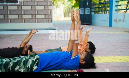 Asian Girl che fa esercizi ginnici o esercitandosi in classe di idoneità con i fratelli piccoli. Foto Stock