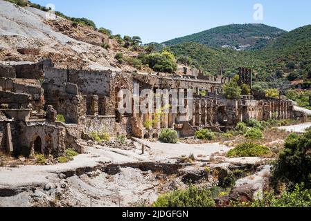 Facciate deteriorate e parti metalliche arrugginite nelle rovine della miniera abbandonata di Naracauli nei pressi di Ingurtosu, Costa Verde, Sardegna, Italia Foto Stock