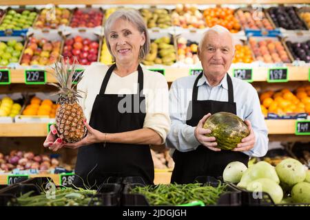 Lavoratori maturi di supermercati in piedi in sala di vendita Foto Stock