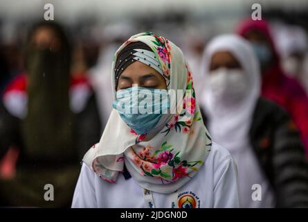 Srinagar, Kashmir controllato dall'India. 21st giugno 2022. La gente esegue lo Yoga nella Giornata Internazionale dello Yoga nella città di Srinagar, la capitale estiva del Kashmir controllato dall'India, 21 giugno 2022. Credit: Javed Dar/Xinhua/Alamy Live News Foto Stock