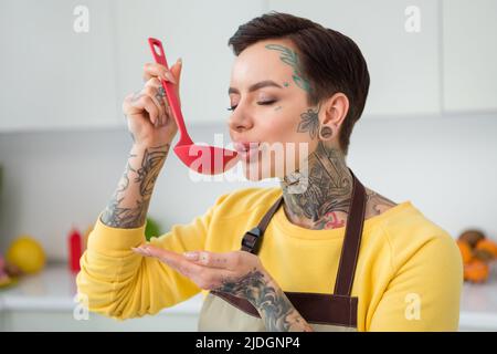 Ritratto di attraente sognante calma ragazza degustazione fresco pasto biologico prodotto zuppa stare al sicuro a casa cucina al coperto Foto Stock