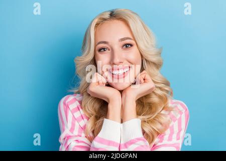 Foto della dolce millenaria bionda hairdo donna mani viso indossare camicia rosa isolato su sfondo blu Foto Stock