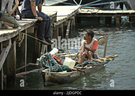 Un pescatore che parla con i giornalisti dalla sua barca durante un viaggio di mezzi di comunicazione a Loh Buaya nell'isola di Rinca, una parte del Parco Nazionale di Komodo a Komodo, Manggarai Occidentale, Nusa Tenggara Orientale, Indonesia. Foto Stock