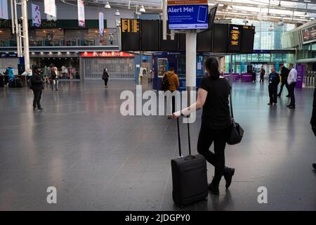 Manchester, Regno Unito. 21st giugno 2022. CommuterÕs possibile controllare i limitati servizi ferroviari disponibili presso la stazione ferroviaria di Piccadilly. Il più grande sciopero ferroviario in oltre 30 anni è andato avanti dopo il fallimento dei colloqui dell'ultimo minuto. RMT afferma di non avere altra scelta se non quella di sciopero a causa dei tagli proposti a posti di lavoro, retribuzioni e pensioni. Credit: Andy Barton/Alamy Live News Foto Stock