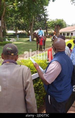 Spettatori che guardano i cavalli che vengono condotti attorno al ring della sfilata prima di una gara, Ngong Racecourse, Ngong Road, Nairobi, Kenya. 1 Mar 2015 Foto Stock