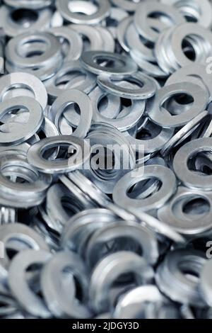 Gruppo di rondelle piane zincate in acciaio inox per viti di fissaggio, dadi o bulloni, fondo bulloneria. Pila di rondelle piatte per la distribuzione del carico di Foto Stock