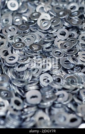 Gruppo di rondelle piane zincate in acciaio inox per viti di fissaggio, dadi o bulloni, fondo bulloneria. Pila di rondelle piatte per la distribuzione del carico di Foto Stock