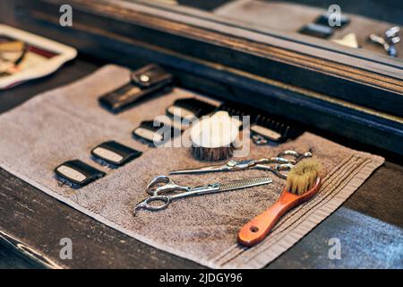 Barbershop haircut strumenti attrezzature barbiere sul fronte in legno del controsoffitto dello specchio, interni in vecchio stile vintage. Utensili per parrucchieri per taglio capelli alla moda, cl Foto Stock