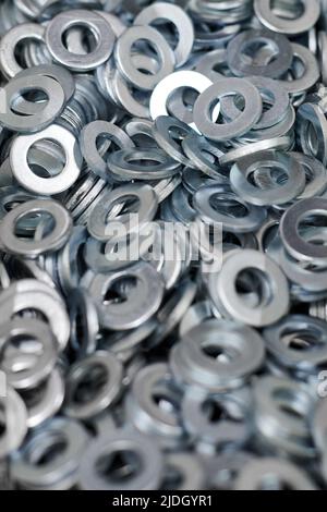 Gruppo di rondelle piane zincate in acciaio inox per viti di fissaggio, dadi o bulloni, fondo bulloneria. Pila di rondelle piatte per la distribuzione del carico di Foto Stock