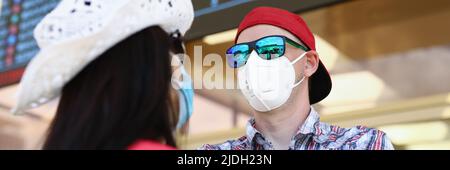 La coppia che va in vacanza durante la pandemia aspetta il volo in aeroporto Foto Stock
