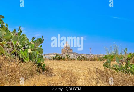 La Chiesa di San Giovanni Battista, Xewkiija, Gozo, vista attraverso i campi agricoli. Foto Stock