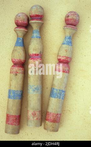 Tre scarpette vintage in legno per bambini con strisce blu e rosse dipinte su carta antica Foto Stock