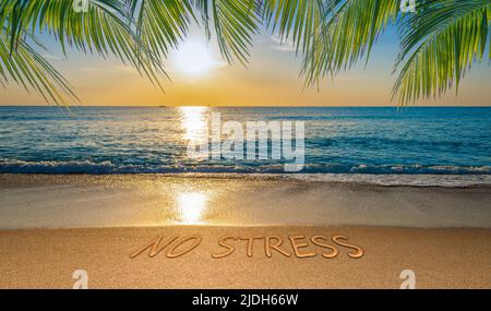 Nessun concetto di stress con spiaggia tropicale e testo scritto nella sabbia. Foto Stock