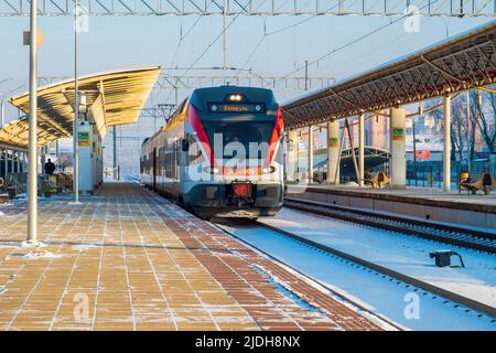 Minsk, Bielorussia - 22 gennaio 2018: Treno elettrico delle linee urbane alla stazione. Una piattaforma vuota. Una giornata invernale limpida Foto Stock