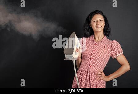 Ferro da stiro per voi. pinup ragazza preparare la stiratura. vintage signora tenere ferro moderno. Vita quotidiana e casalinghi. Donna retrò con ferro. Cameriera allegra Foto Stock