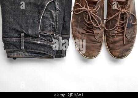 Scarpe in pelle marrone vintage e jeans neri elegantemente stressati isolati su sfondo bianco. Stile di vita e moda. Top wiev con spazio di copia Foto Stock