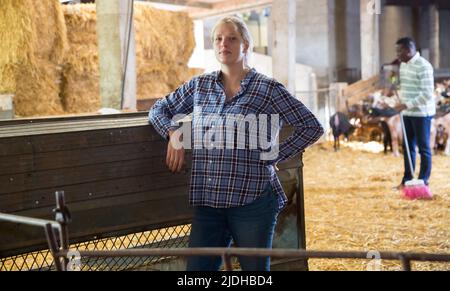 Due dipendenti che lavorano nel fienile di bestiame Foto Stock