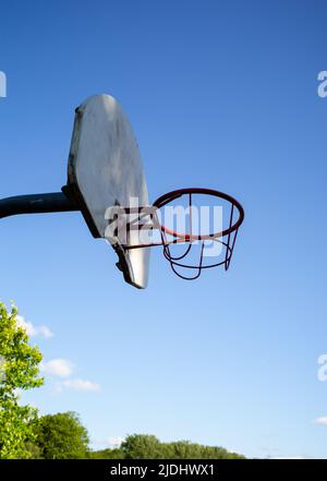 Cerchio e tavola da basket in metallo contro un cielo blu intenso e senza nuvole con spazio copia. Illuminato dalla luce del sole. Foto Stock