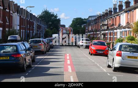 I collettori di rifugio bloccano la strada con il camion di smaltimento come raccolgono i rifiuti dalla strada stretta delle case di terrazza del centro della città di Eastleigh. Foto Stock