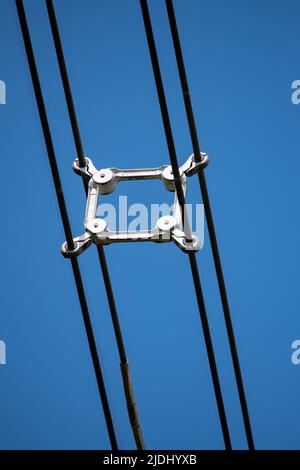 Primo piano degli spaziatori su una torre reticolare elettrica nel Regno Unito che separa i cavi ad alta tensione. Foto Stock