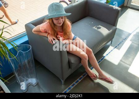 Ragazza su una sedia all'ingresso di Marineland Foto Stock