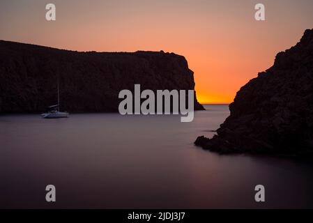 Uno yacht si ancora al crepuscolo nella baia fiordo di Cala Domestica nel sud-ovest della Sardegna, Iglesiente, Italia Foto Stock