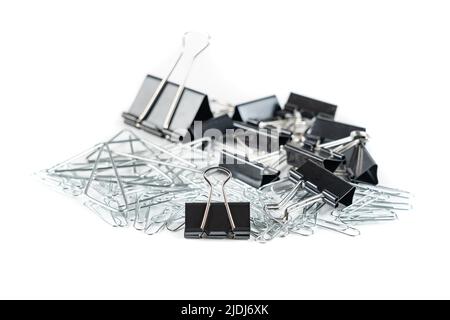 Set di clip e morsetti di diverse dimensioni per contenere fogli di carta, isolati su sfondo bianco. Foto Stock