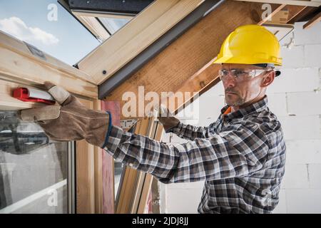 Il Contraente professionista si è concentrato sul suo lavoro testando la funzionalità dei finestrini del tetto appena installati in un nuovo edificio in costruzione. Foto Stock