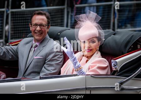 L'attrice Dame Joan Collins e il marito Percy Gibson ondano da una Jaguar d'epoca durante la sezione 'ames in Jags' del Platinum Jubilee Pageant come me Foto Stock