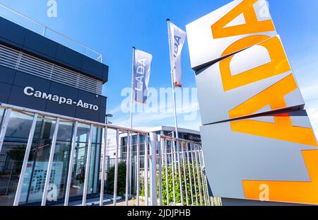 Samara, Russia - 18 giugno 2022: Cartello della concessionaria e bandiere del concessionario ufficiale Lada. Lada è un'azienda automobilistica russa. Testo in russo: SA Foto Stock