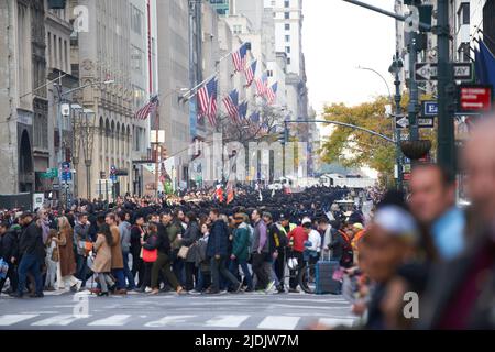 Manhattan, New York, USA - Novembre 11. 2019: Persone che attraversano Fifth Avenue a NYC durante la Veterans Day Parade. Membri delle forze armate in background Foto Stock