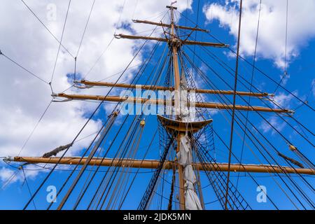 Grande albero di una nave a vela con il cielo blu e le nuvole sullo sfondo Foto Stock
