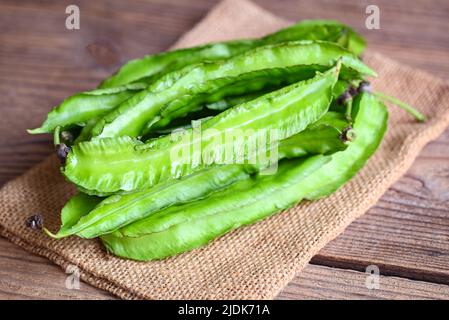 Fagiolo alato su fondo di sacco, Psofocarpus tetragonolobus - fagiolo alare verde o fagiolo a quattro angoli Foto Stock