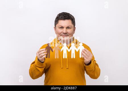 Ritratto di uomo medio invecchiato dai capelli scuri che tiene catena di carta di persone, popolazione, razza e concetto di etnia, indossando felpa con cappuccio in stile urbano. Studio interno girato isolato su sfondo bianco. Foto Stock