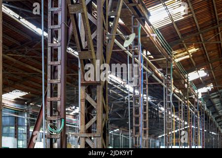 Colonne portanti con struttura a telaio in acciaio in officina abbandonata Foto Stock