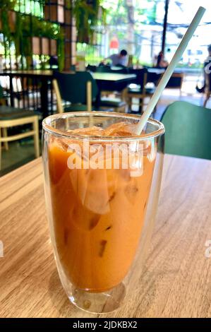 Bangkok, Tailandia. 18th giugno 2022. Il tè freddo Cha Yen è abbastanza al gusto del Thais - vale a dire piuttosto dolce e tuttavia molto rinfrescante nelle temperature calde tutto l'anno. La famosa bevanda fredda è disponibile in ogni angolo da Bangkok a Phuket. Il colore è inconfondibile: Il 'Thai Ice Tea' si illumina in arancio soleggiato. (A dpa 'Halo-Halo, Gazoz e Pea di farfalle: Bevande estive in tutto il mondo') Credit: Carola Frentzen/dpa/Alamy Live News Foto Stock