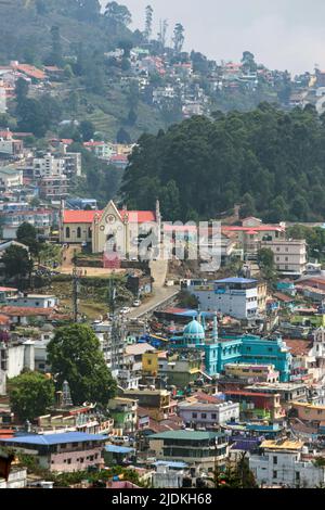 Vista aerea della città di Kodaikanal dalla fermata dell'autobus. Chiesa del Sacro cuore e case viste sullo sfondo. Kodaikanal, Tamilnadu, India. Foto Stock