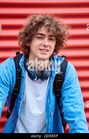 Giovane uomo elegante in abiti casual mentre si appoggia su una bicicletta e si guarda la macchina fotografica. Foto Stock